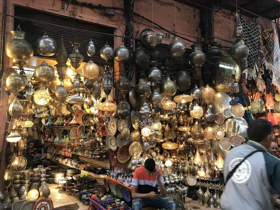 A busy market stall selling traditional Moroccan lamps.