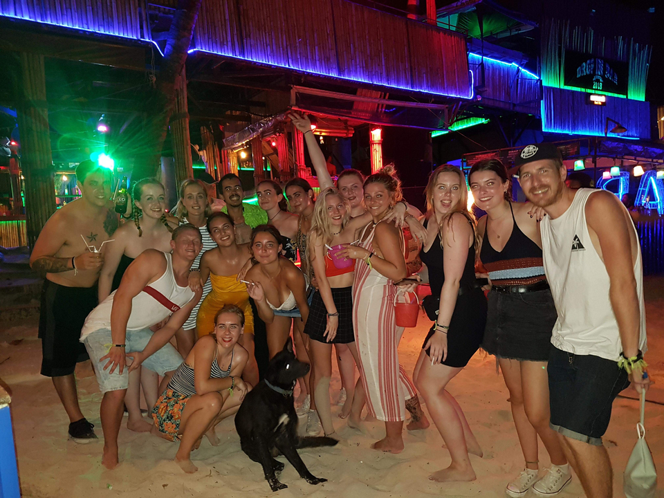 Group of people posing in a vibrant bar environment.