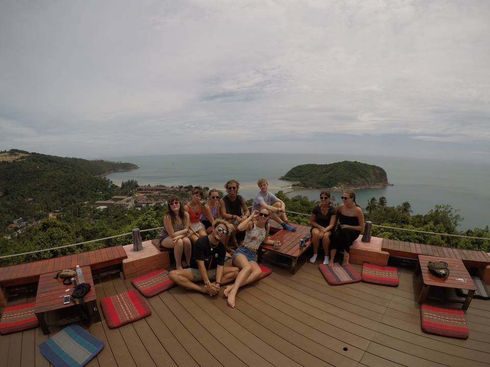 Group of people relaxing on a terrace with ocean views.