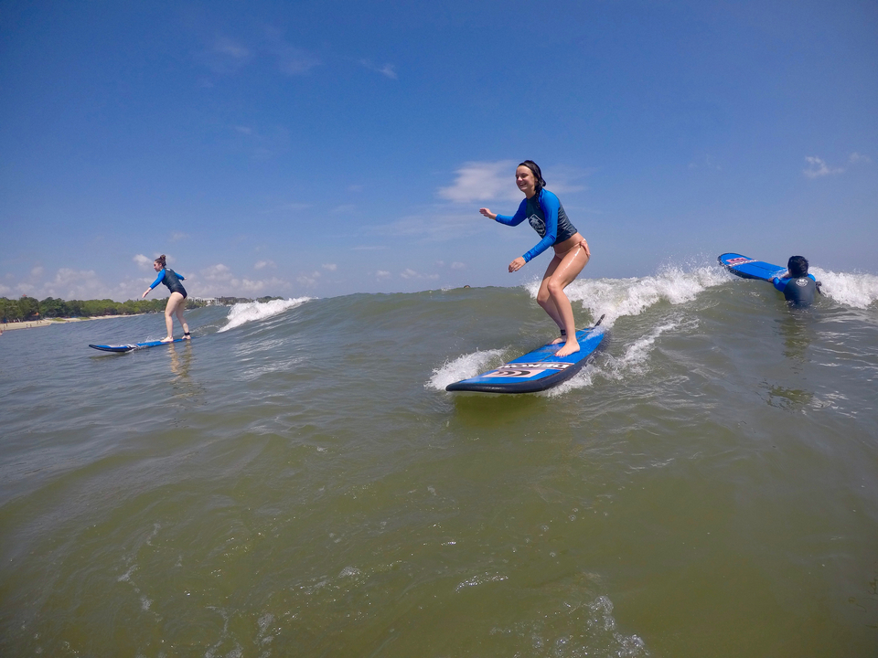 People catching waves while surfing in the ocean.