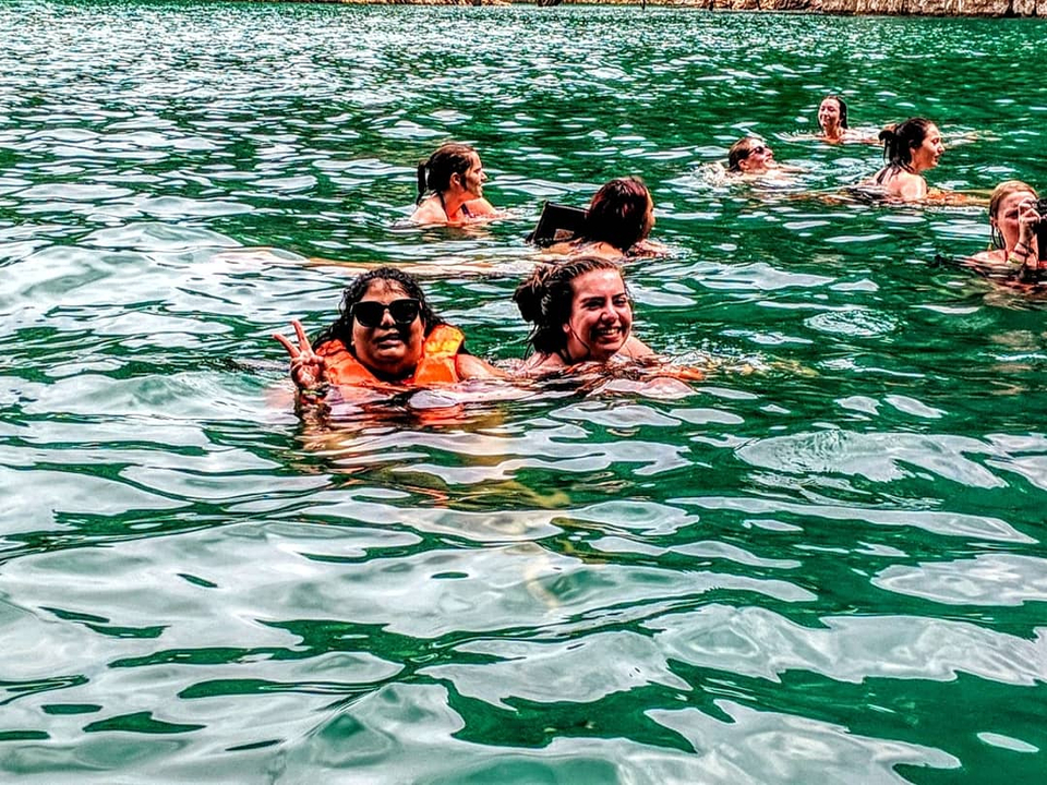 People swimming in green water.