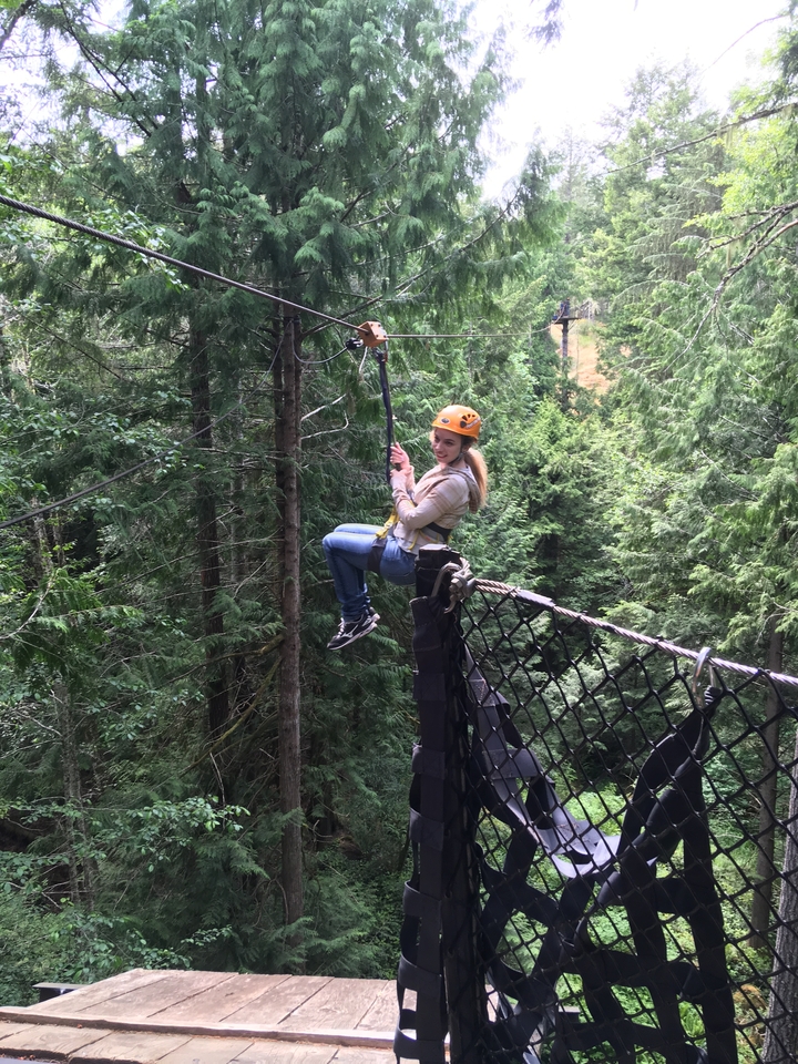 A person zip-lining through a forest.