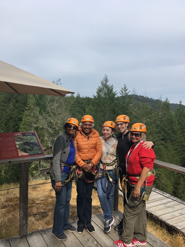 Group of people wearing helmets and harnesses in a forest