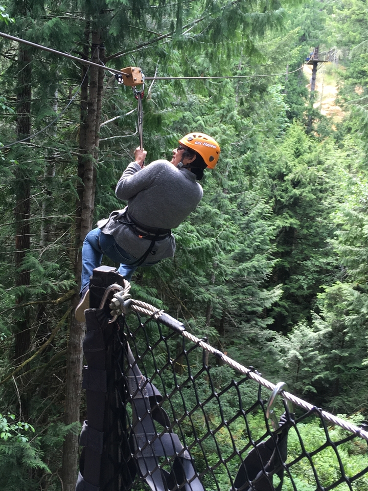 Person zip-lining through a forest