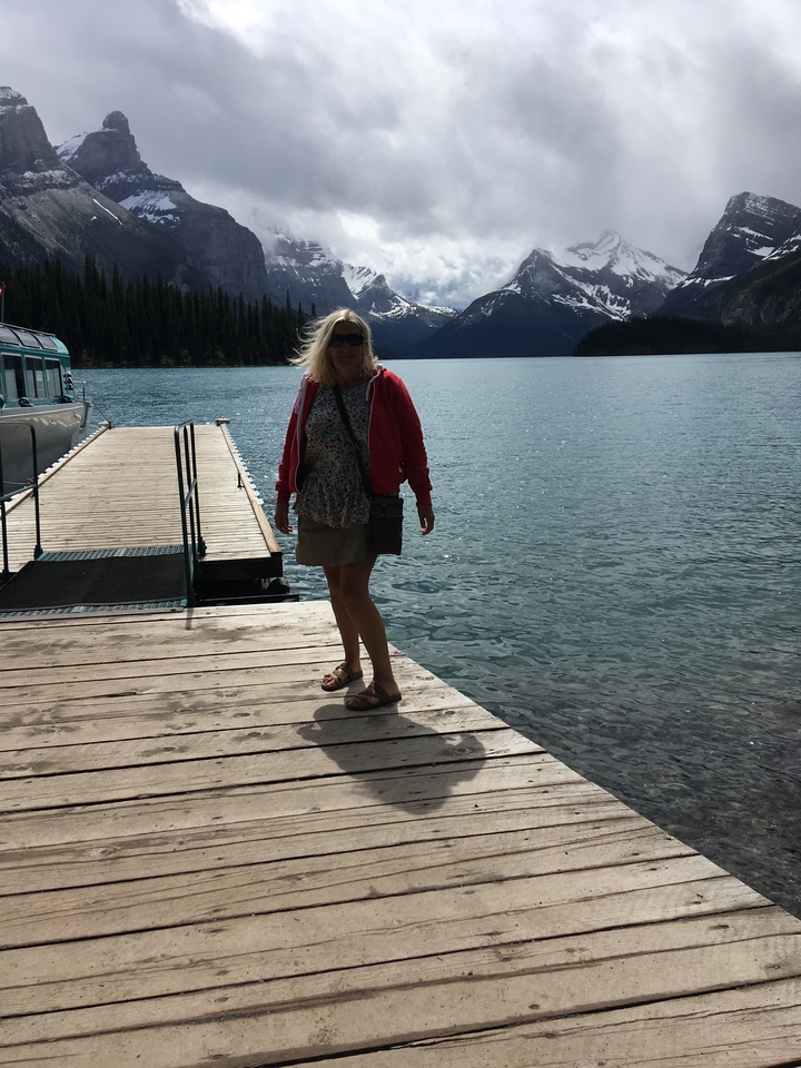 Person standing on a dock by a serene lake