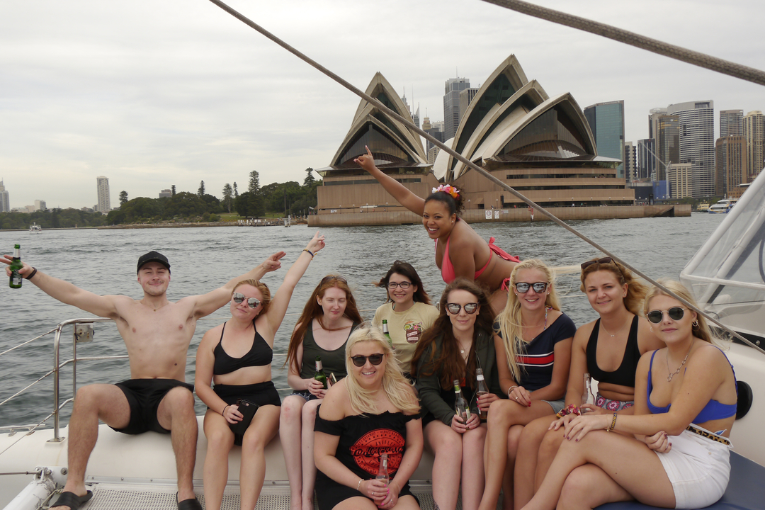 Group enjoying a boat ride with the Sydney Opera House in the background.