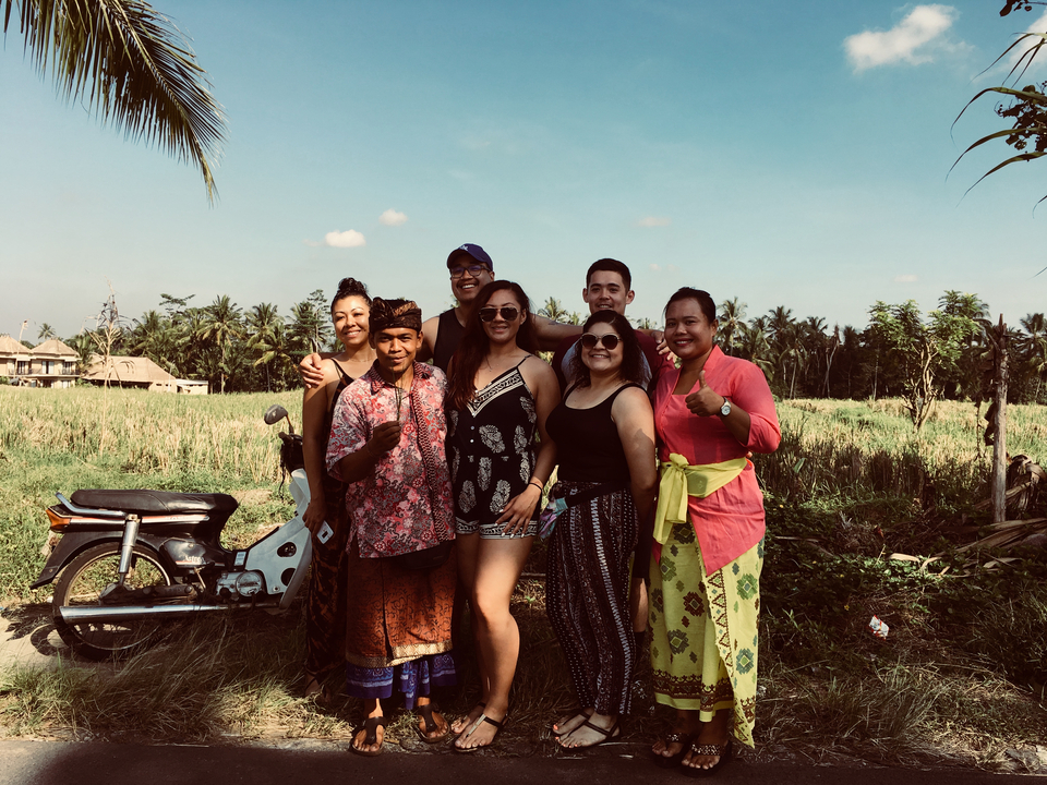 Group of local and tourists near a rice field.