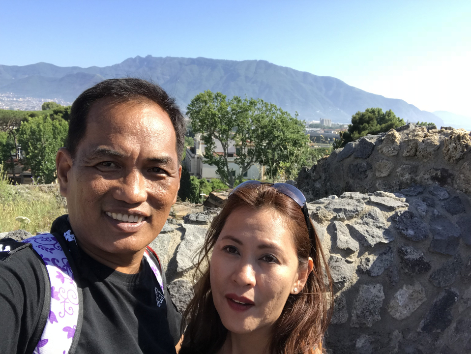 Two people posing with a scenic mountain view.