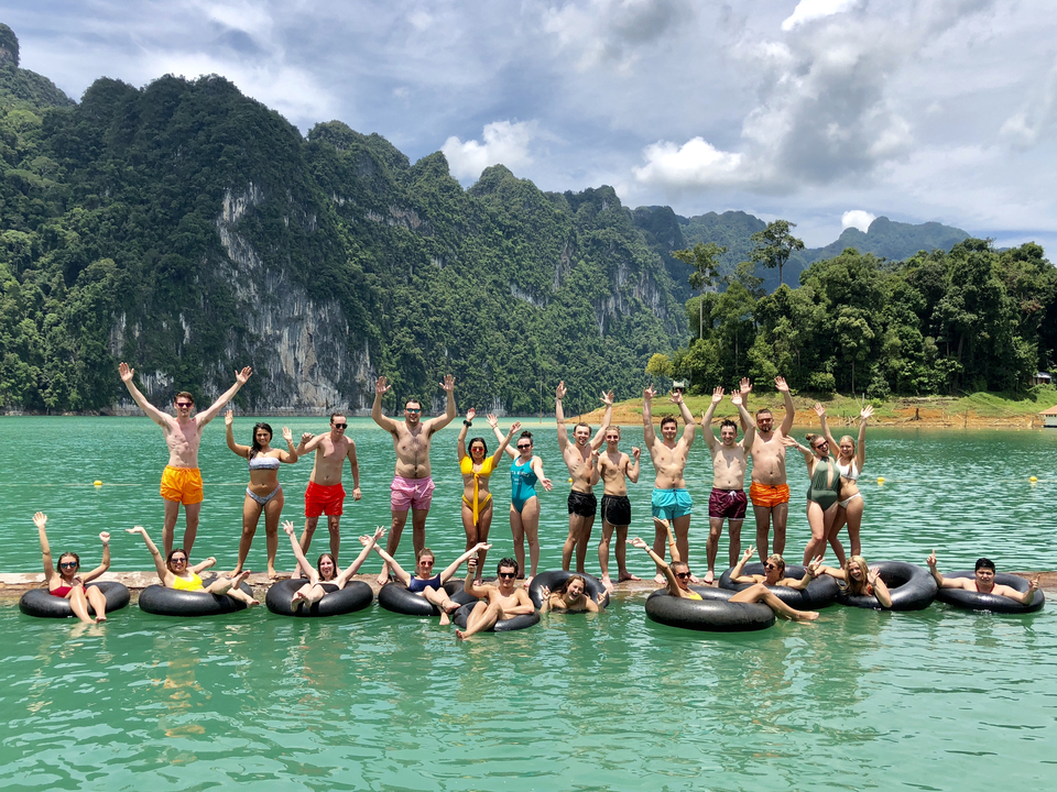 Group of people enjoying a floating platform on a lake.