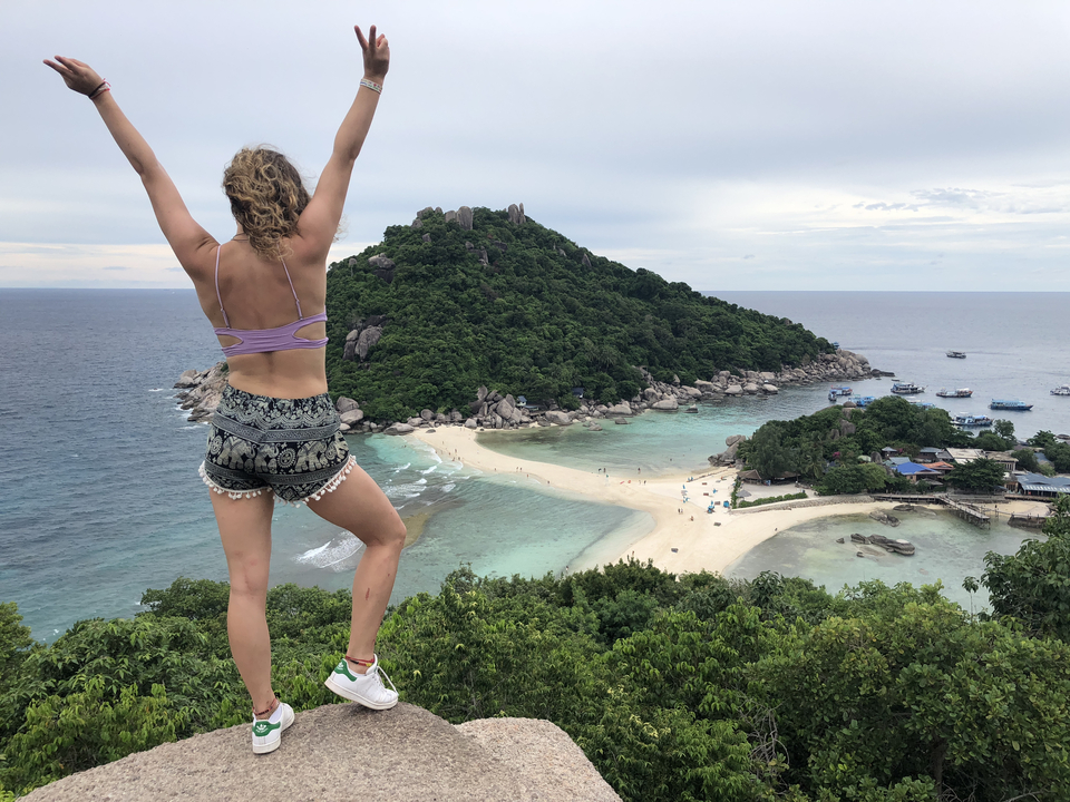 Person enjoying a view of a small island with a sandbar.