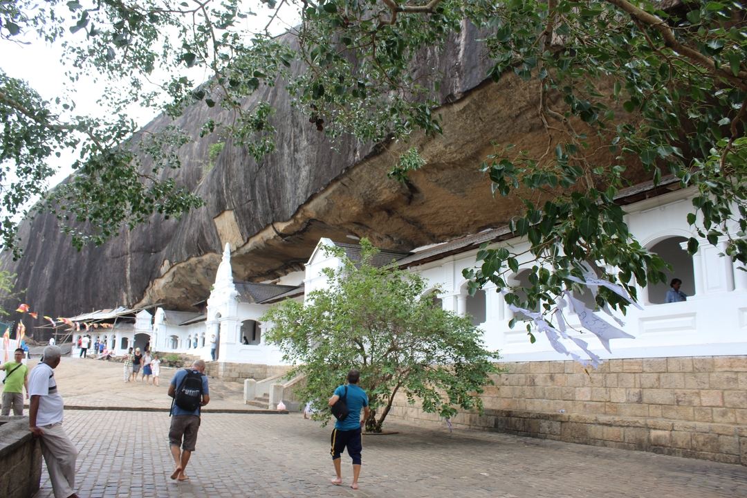 Visiteurs explorant un site historique à l'architecture rupestre.