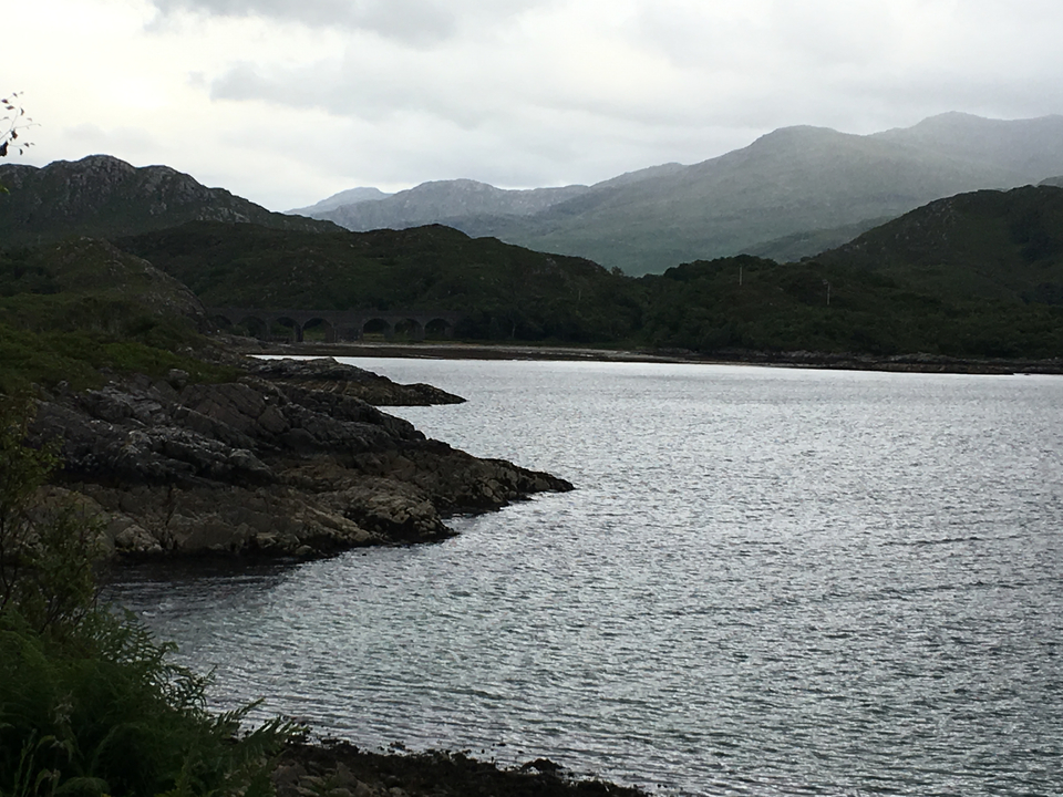 Rocky shoreline with distant hills.