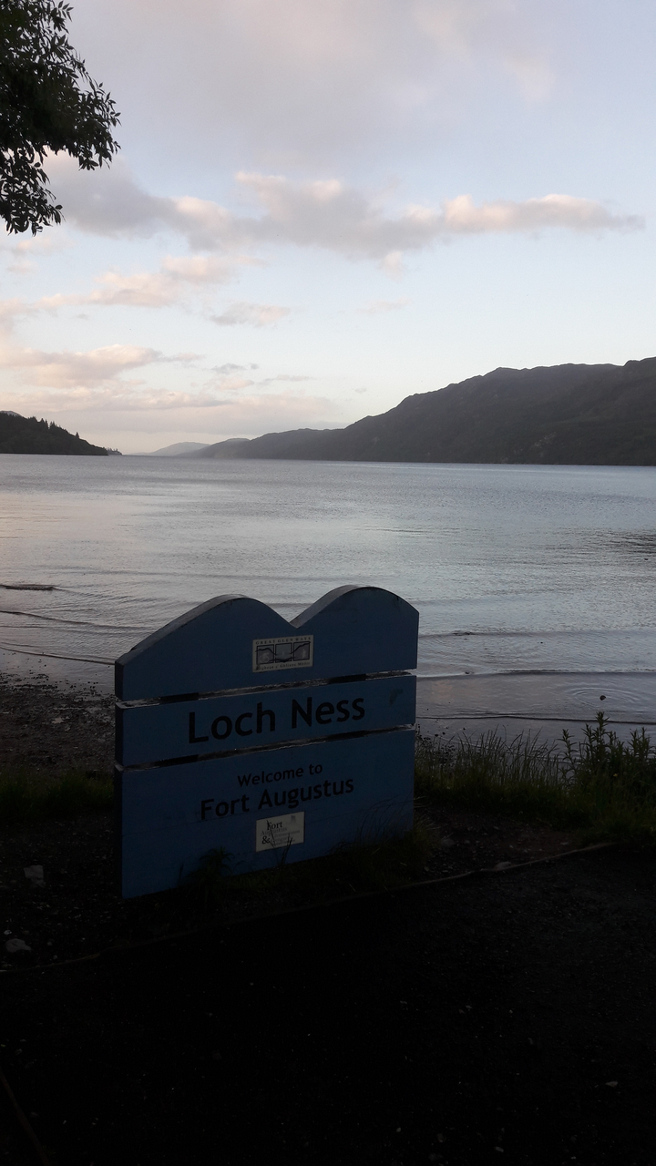 A large lake with a sign for Loch Ness.