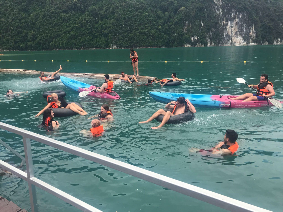 People swimming and kayaking in a lake.