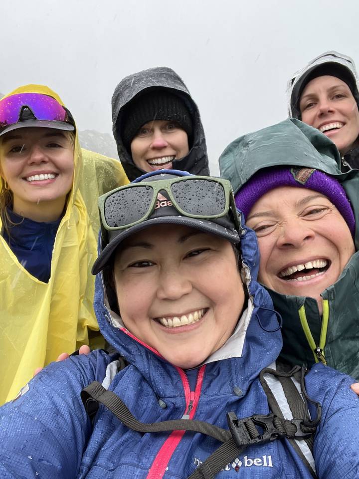 Group of people wearing rain gear, smiling.