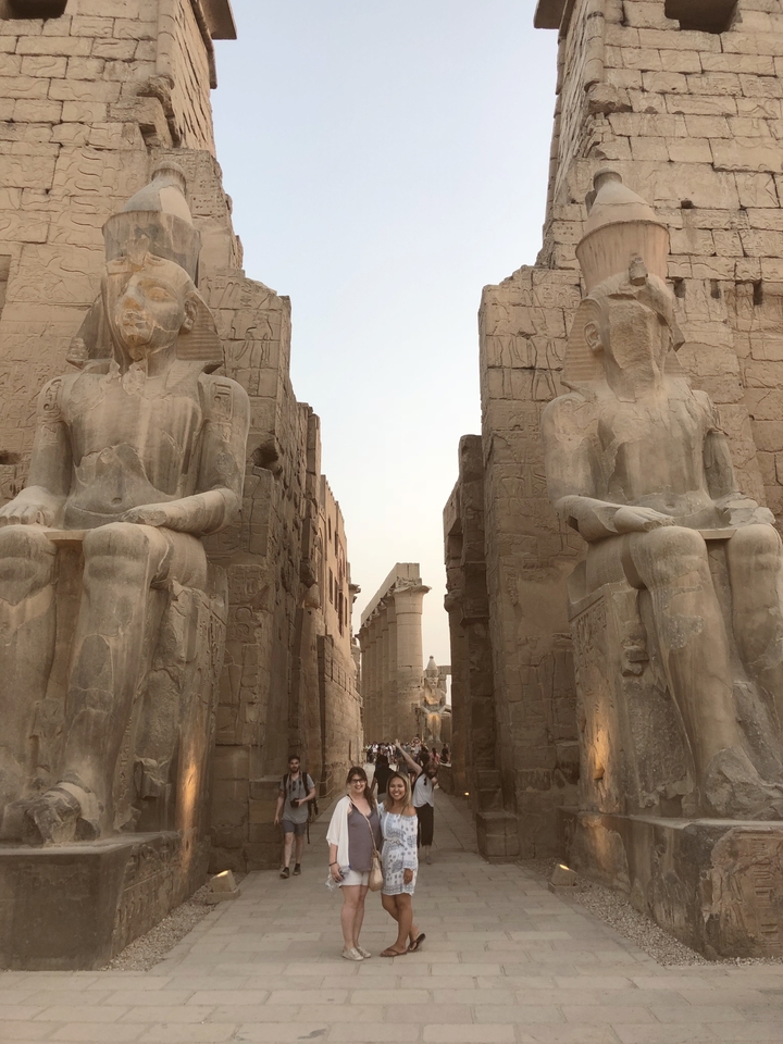 View of large stone statues in Luxor with ancient architecture.