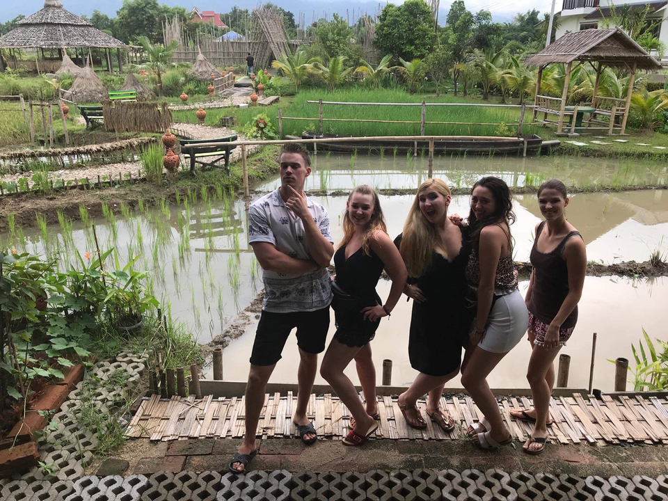 Group posing in front of a rice farm.
