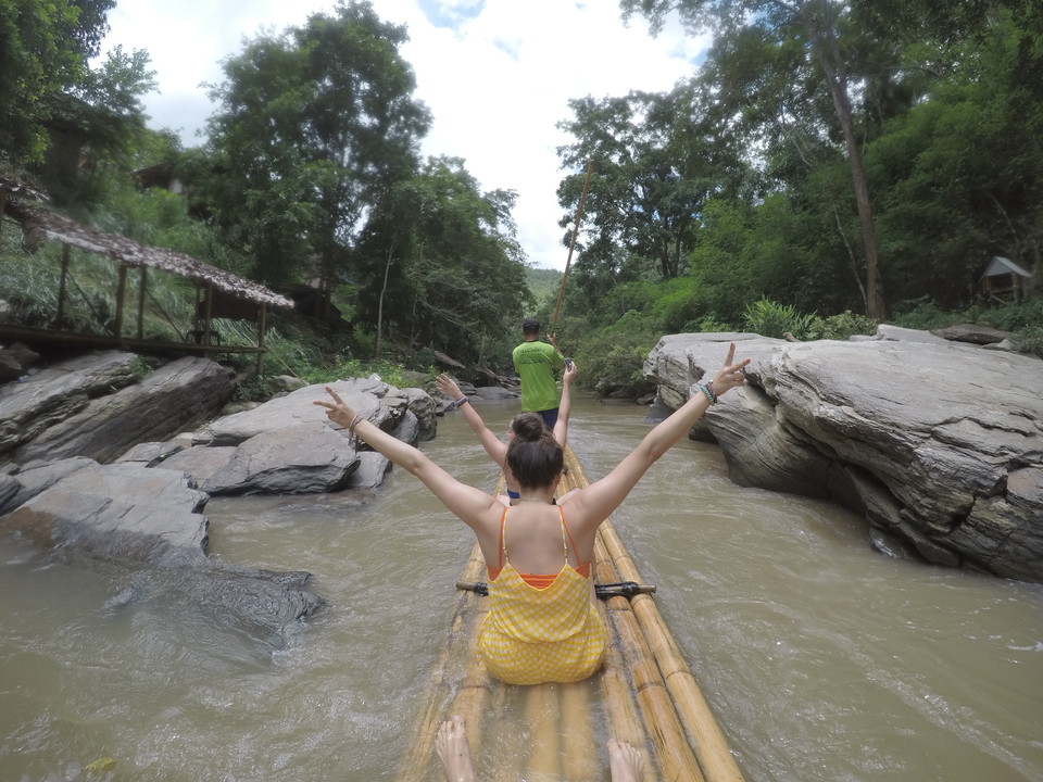 Rafting on a river with scenic rocks and trees.