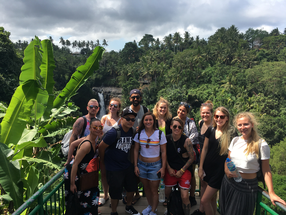 Group posing with a waterfall in the background.