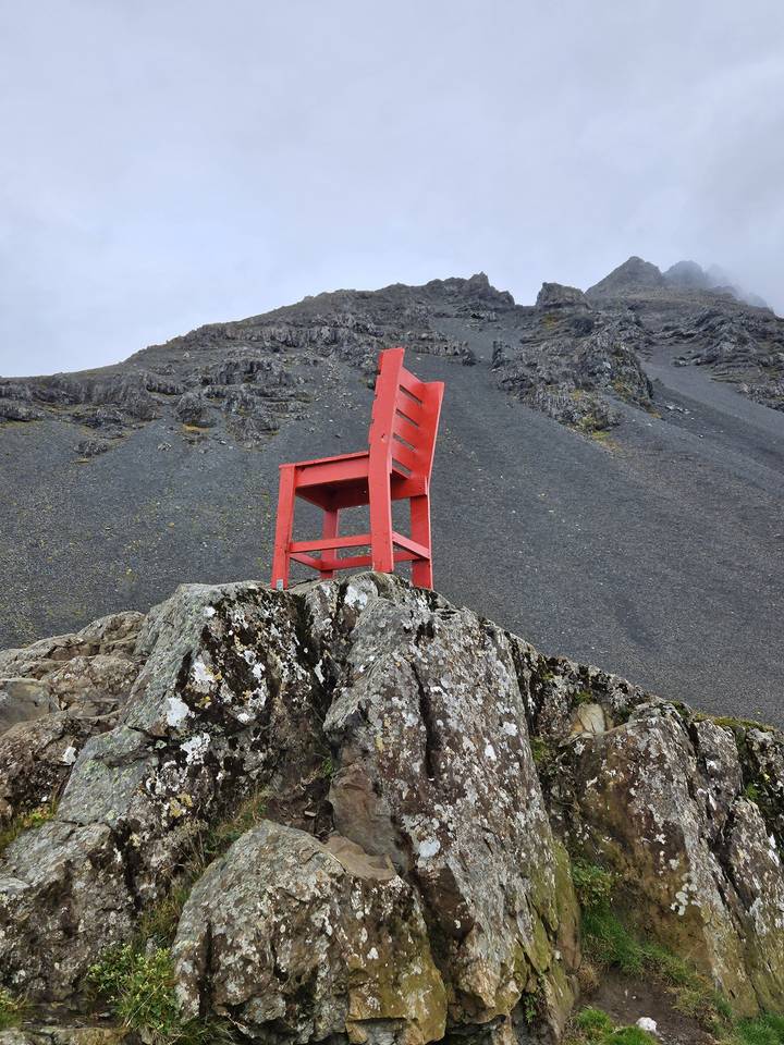 Red chair on rocky terrain.