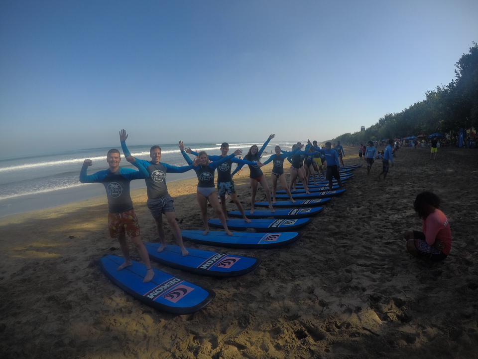 People learning to surf on the beach, image is slightly blurry.
