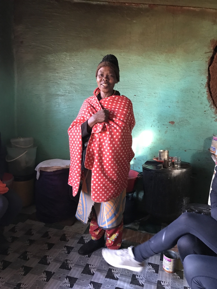 Personne debout à l'intérieur, enveloppée dans une couverture à pois rouges.