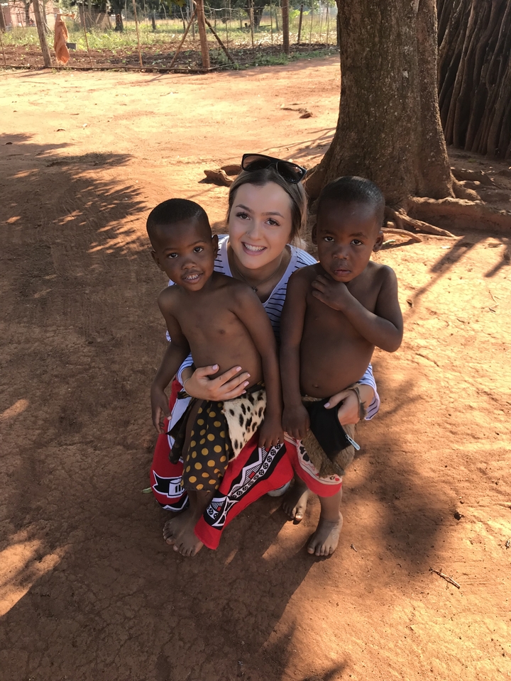 Personne posant avec deux enfants en tenue traditionnelle.