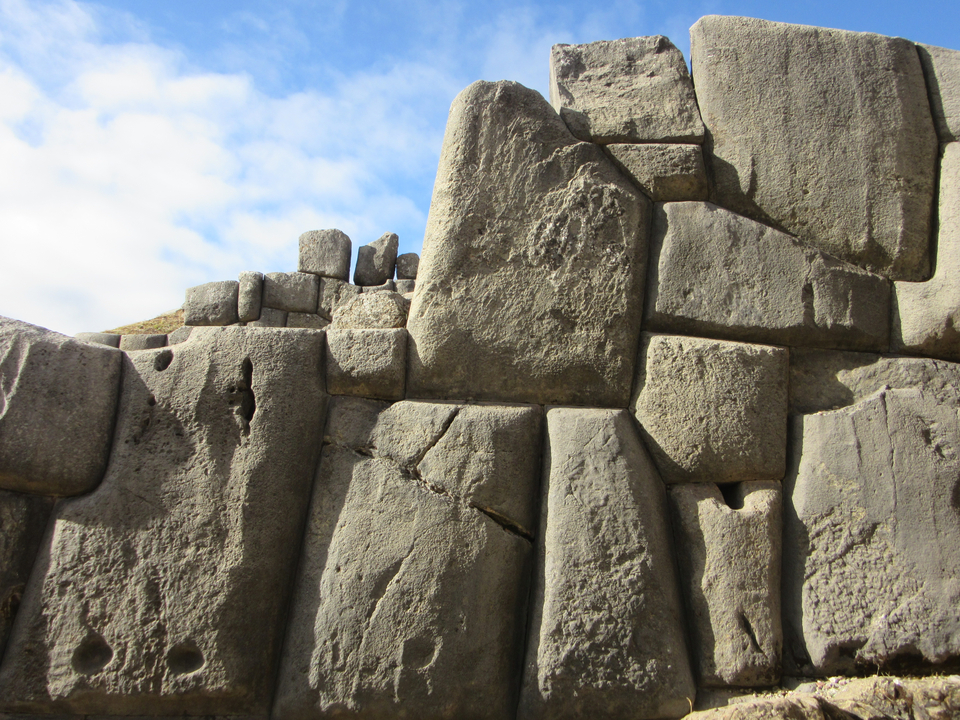 Ruines en pierre d'une ancienne structure sur fond de ciel bleu.