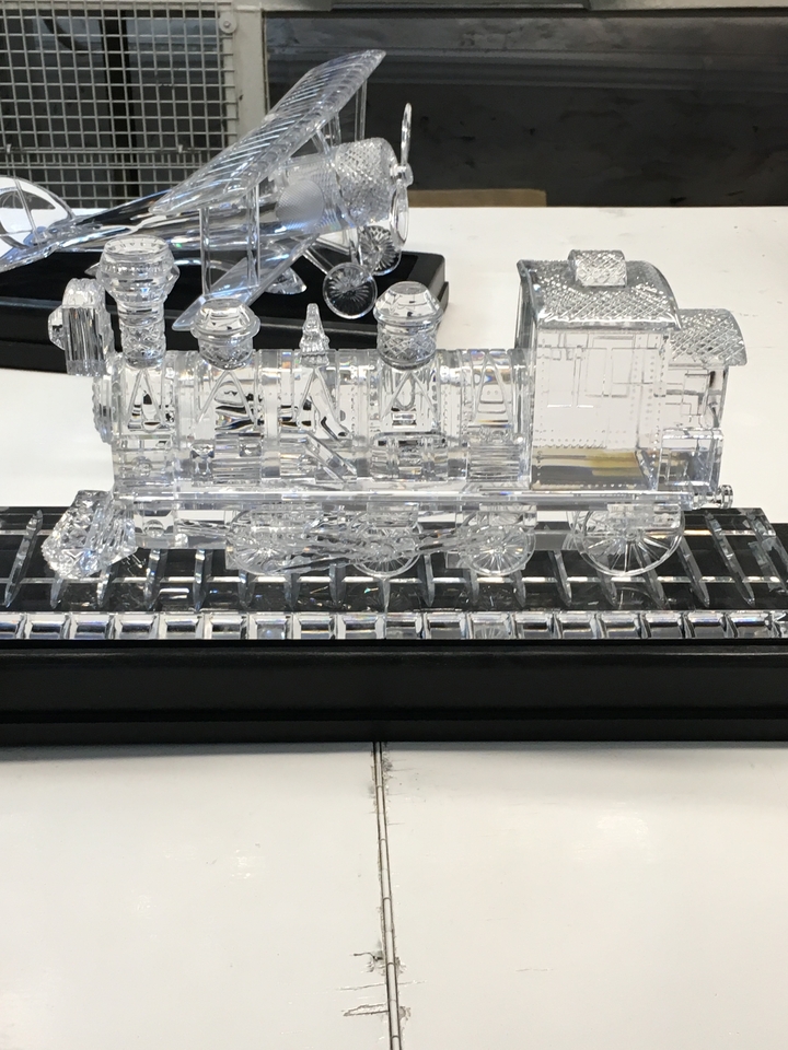 A glass sculpture of a train on display.