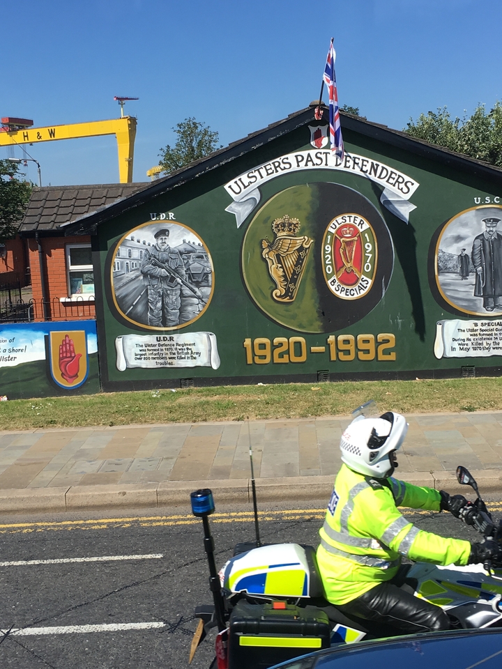 A mural on a wall with historical symbols and writing.