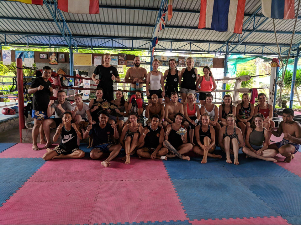 Large group posing in a gym-like setting.