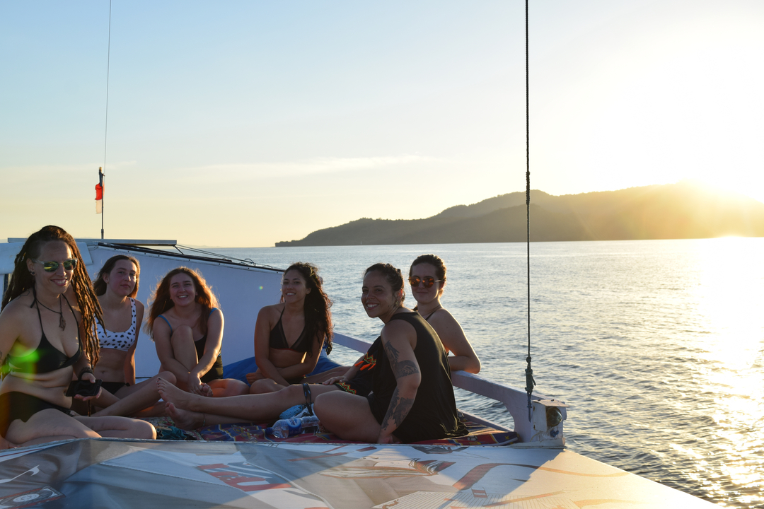 Group of people on a boat during sunset.