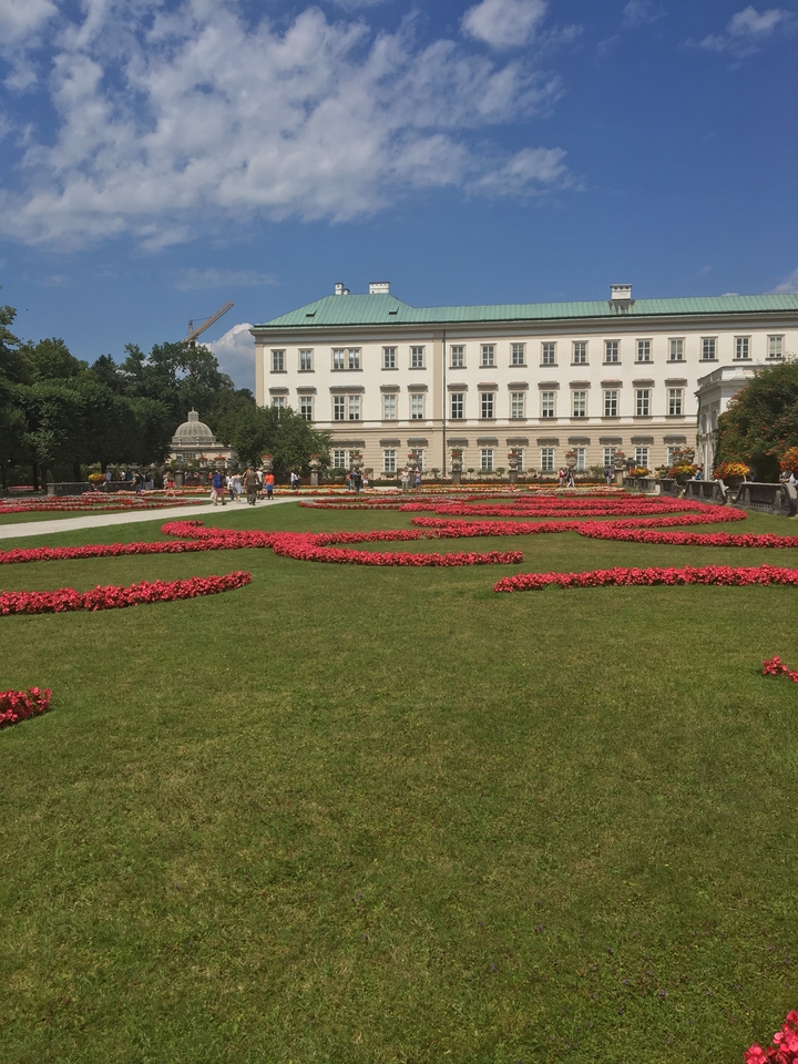 Beautiful garden with ornate flower beds and historic architecture.