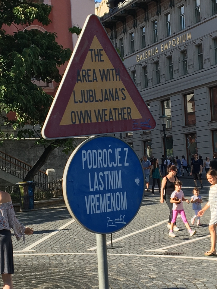 Close-up of street signs with people in the background.