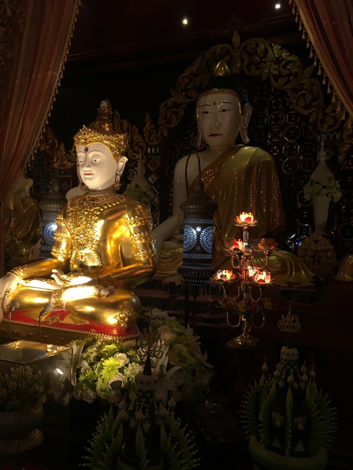 Golden statues inside a temple, beautifully lit.