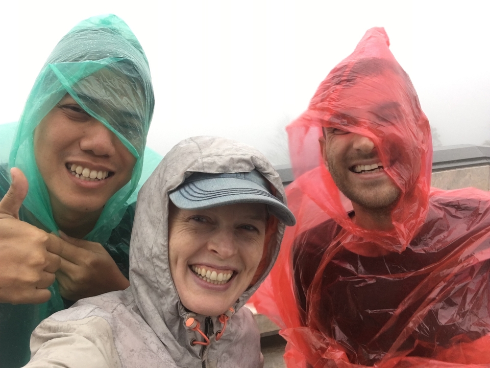 Group of people wearing rain ponchos, smiling for the camera.
