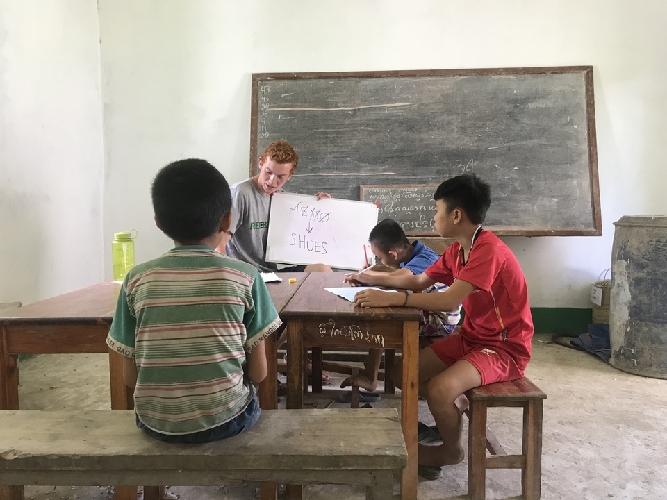 Person teaching children in a classroom setting.