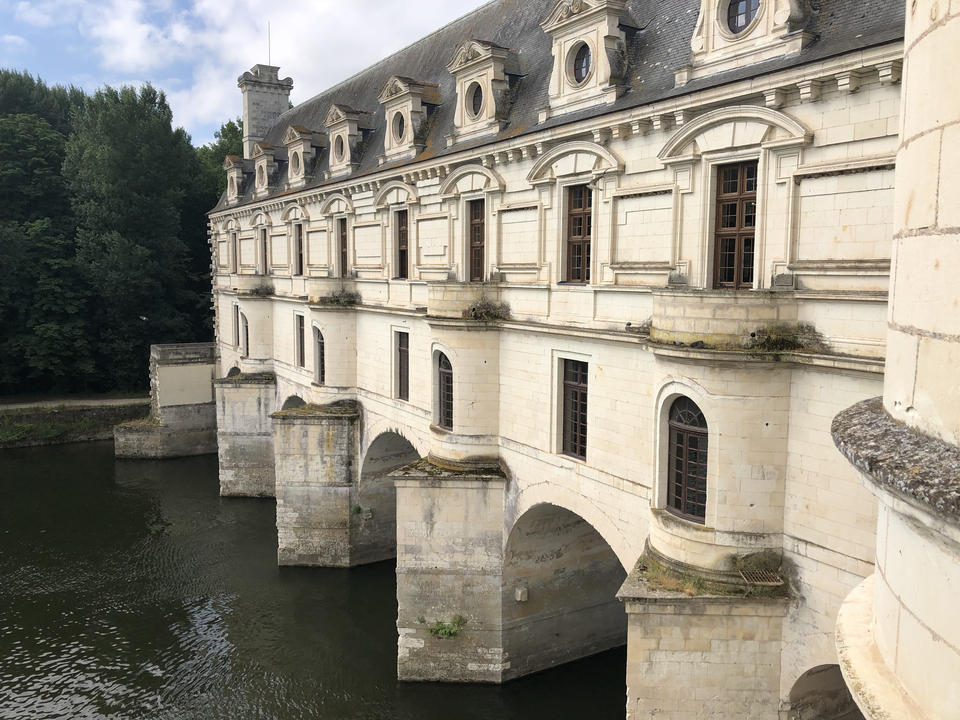 Château enjambant une rivière avec des arches.