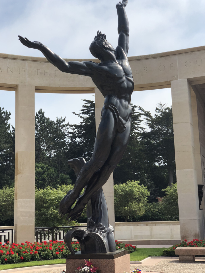 Statue avec piliers et arbres environnants.