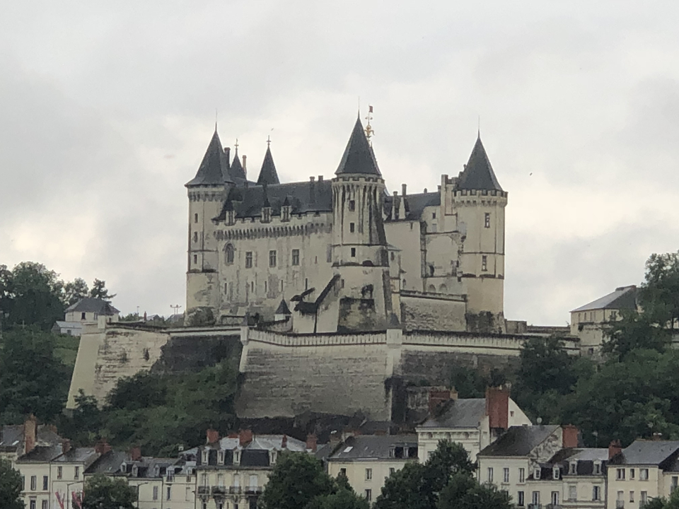 Château sur une colline avec un ciel nuageux.