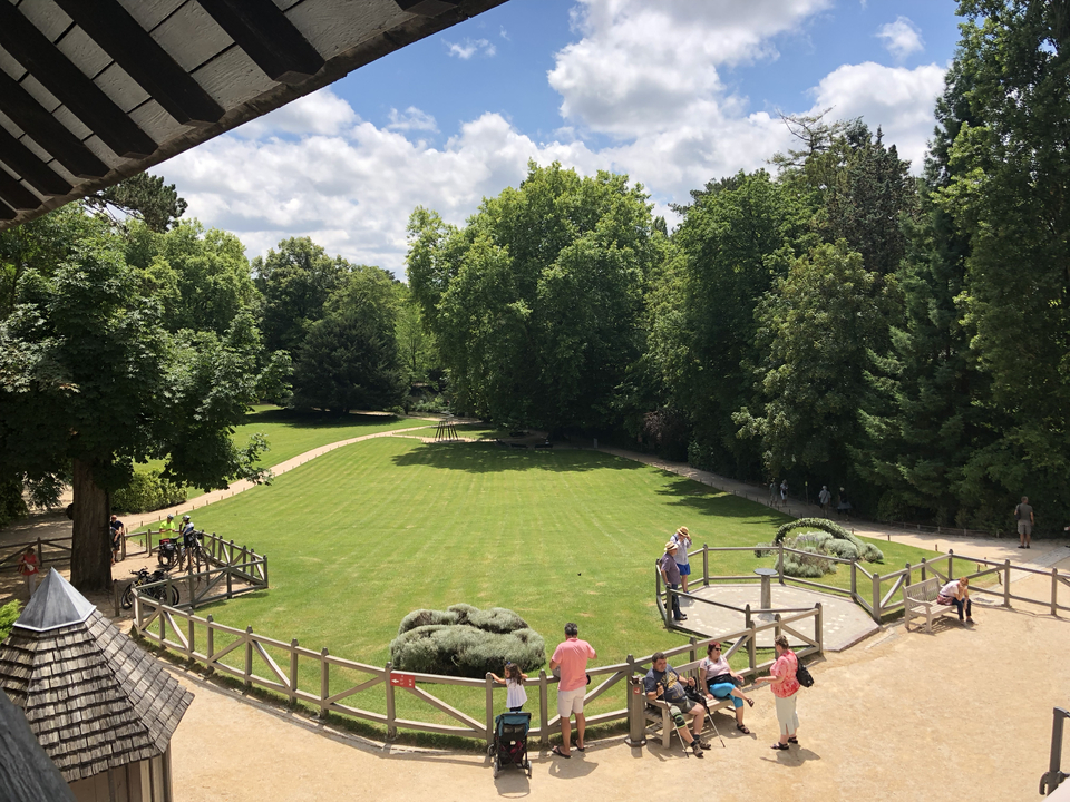 Parc avec des gens qui marchent et des arbres autour.