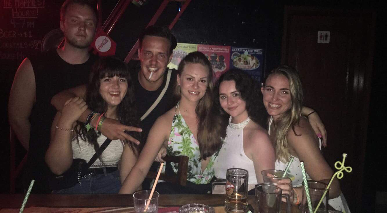 Group of people smiling inside a dimly lit place
