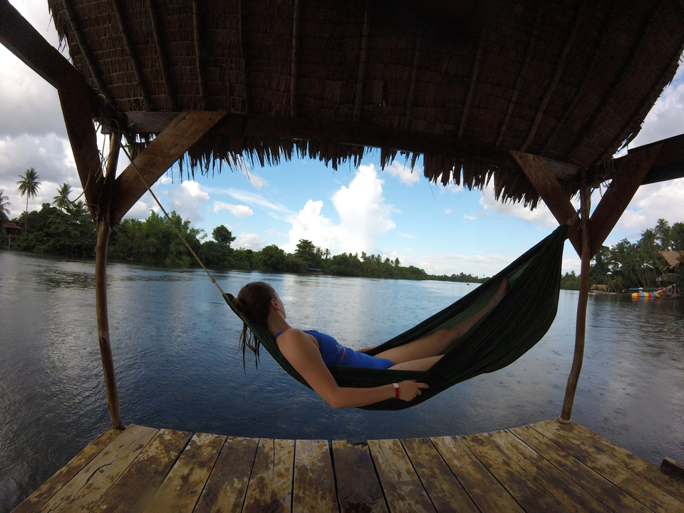 Woman relaxing on a hammock over water