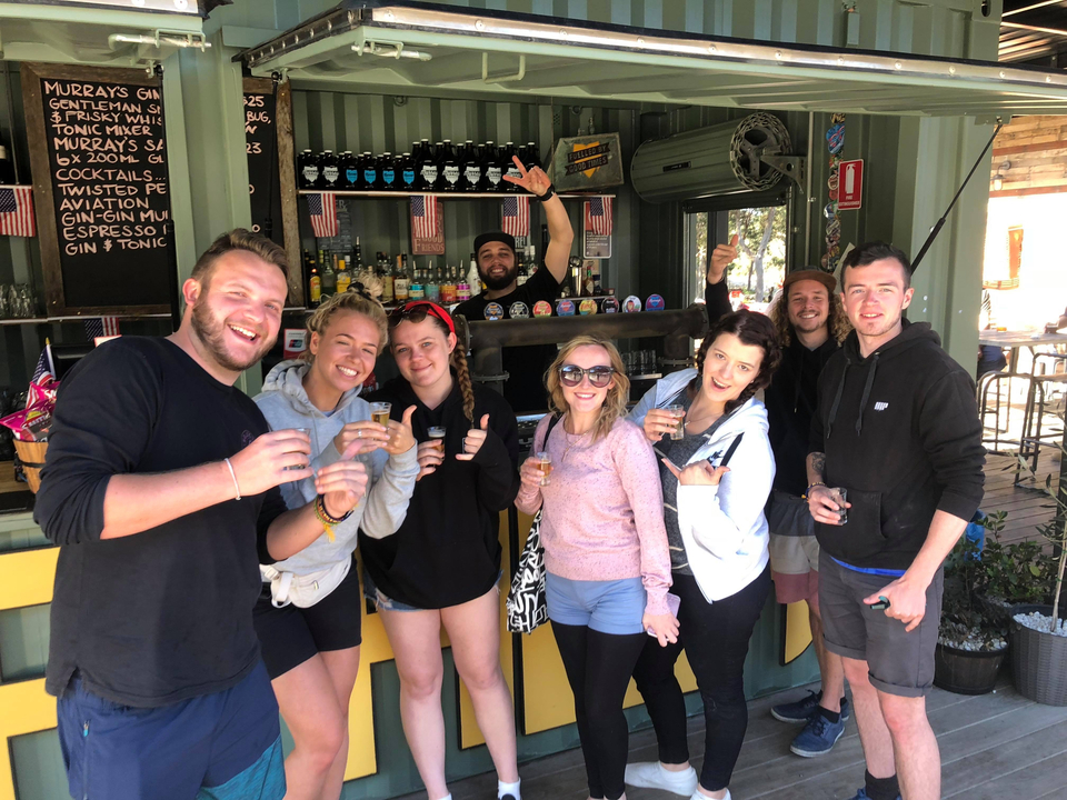Group posing with drinks at a bar.