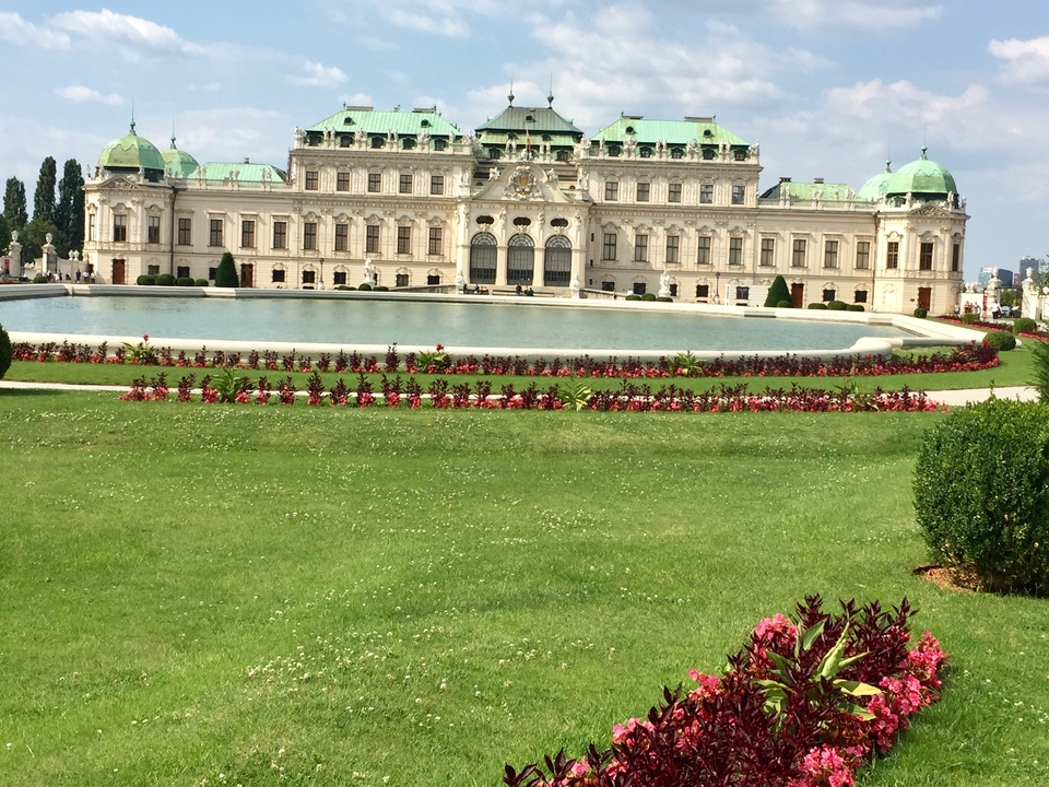 Grand historical palace with fountain and gardens.