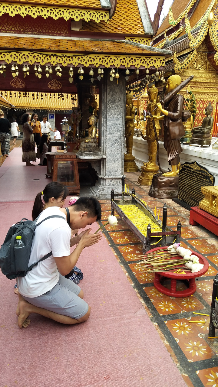 People praying in a temple setting.