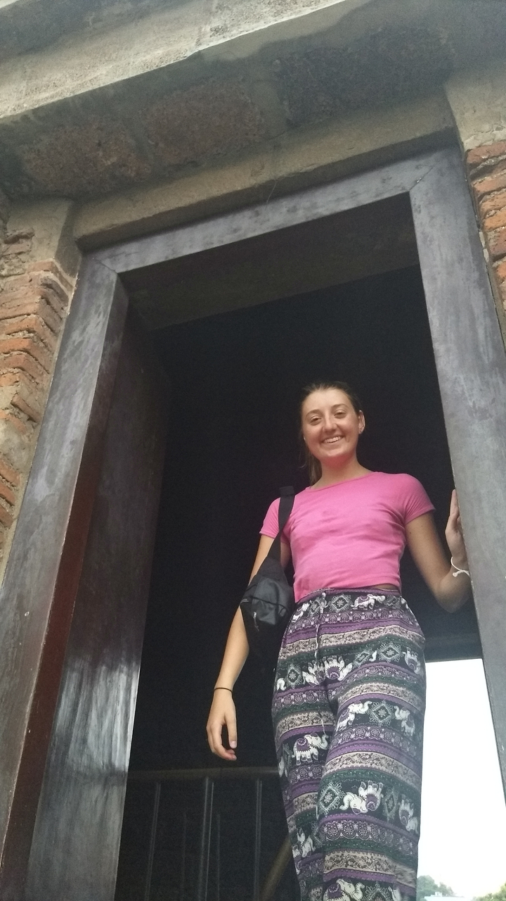 Person smiling, leaning on a doorframe.