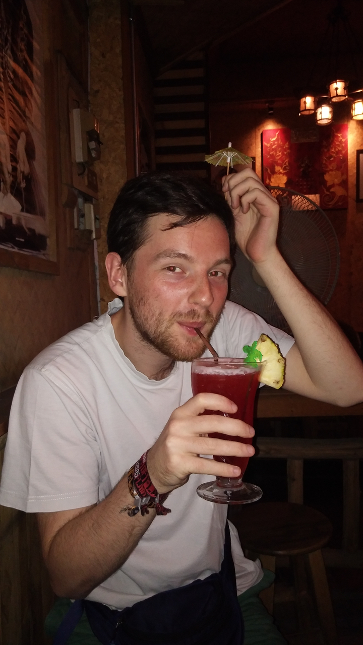 A person enjoying a fruity cocktail.