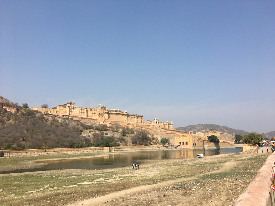 A fort near a body of water with people in the foreground.
