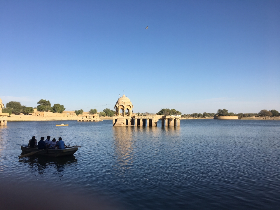 Un lac avec des gens dans des bateaux et des ruines architecturales.